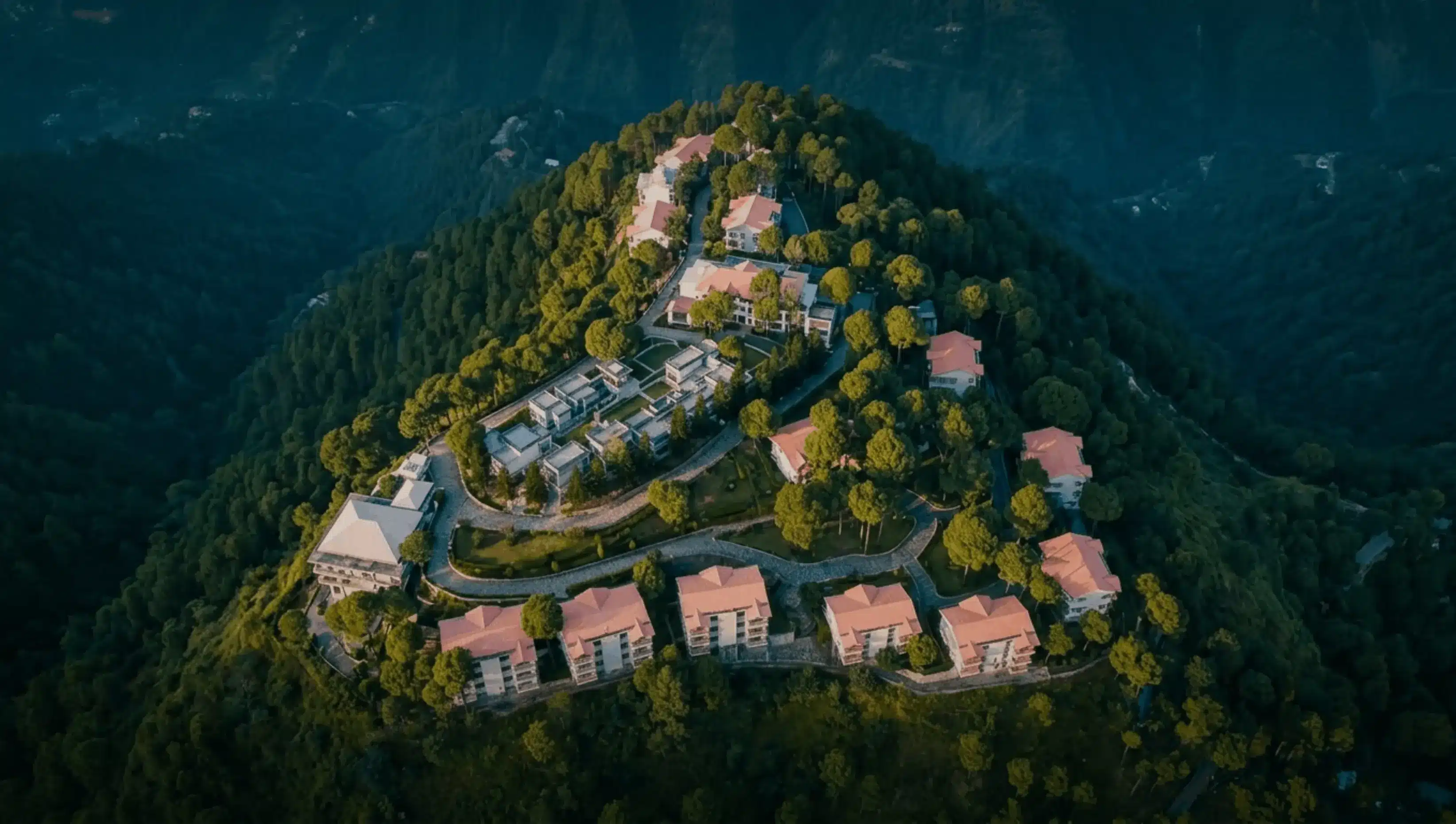 Moksha Himalaya Spa Resort from above, held by the pine ridges of the Shivalik hills